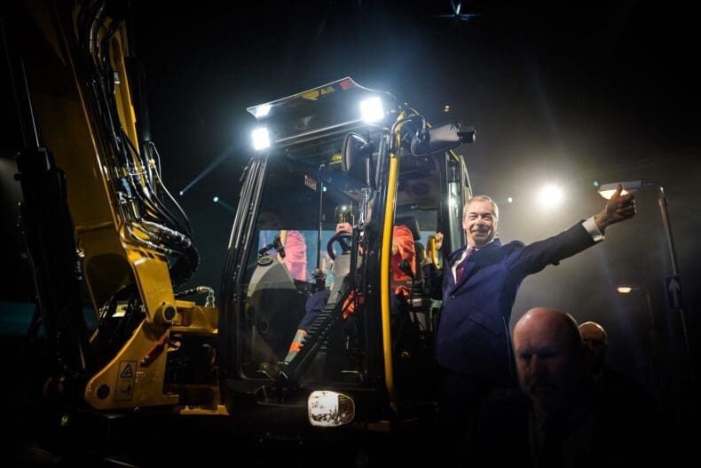 Nigel Farage enters the rally on a JCB